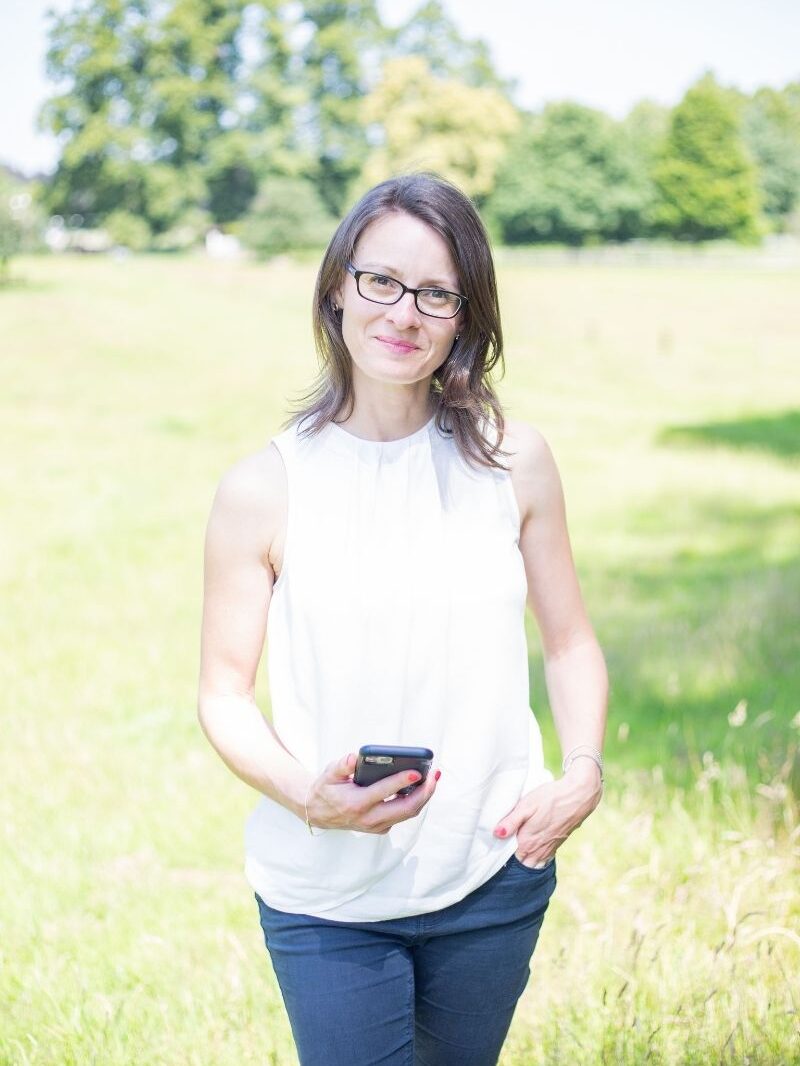 Sarah in field holding iphone