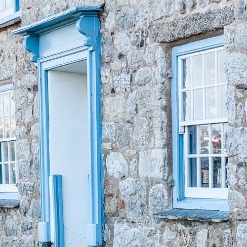 Image of a Cornish cottage with soft blue window frames, very on brand of Sarah
