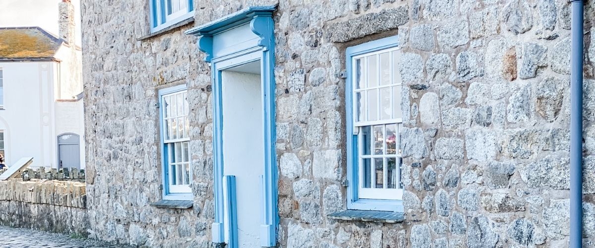 Image of a Cornish cottage with soft blue window frames, very on brand of Sarah