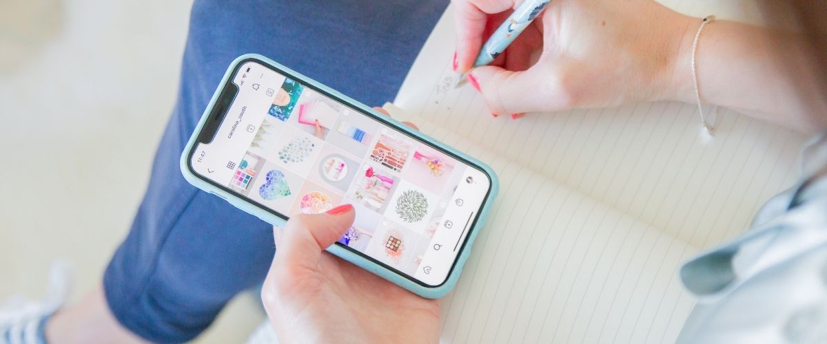 Image of Sarah looking at an Instagram account and taking notes