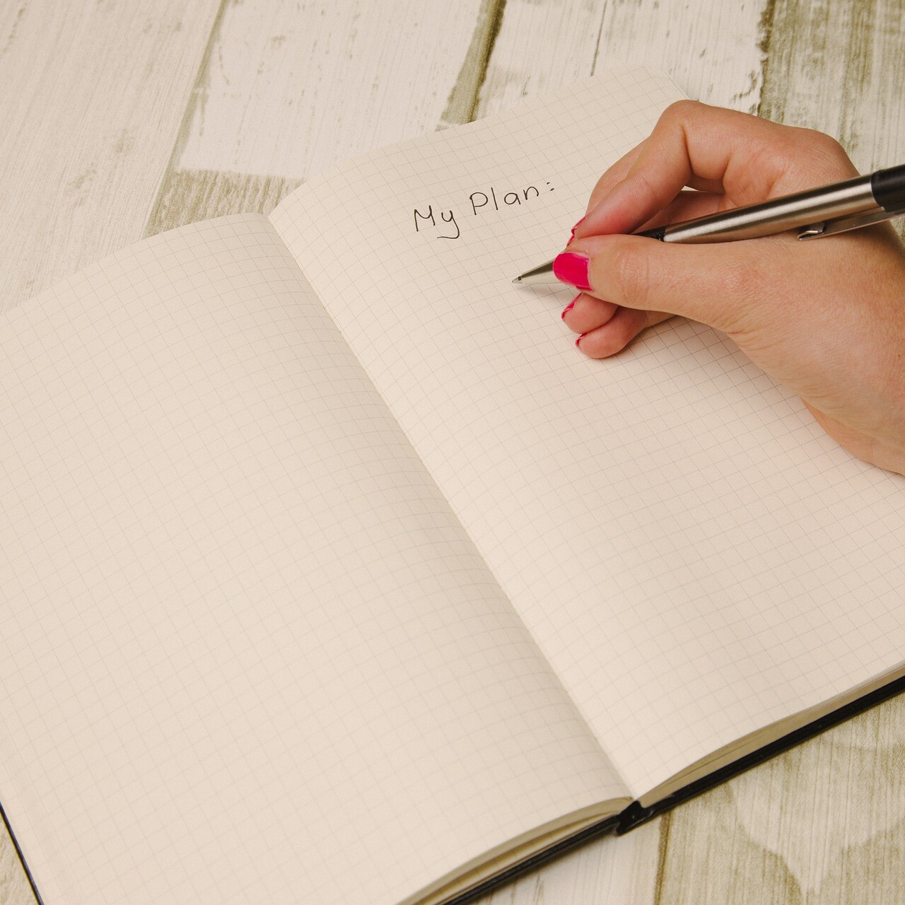 notebook and pen handwriting a plan