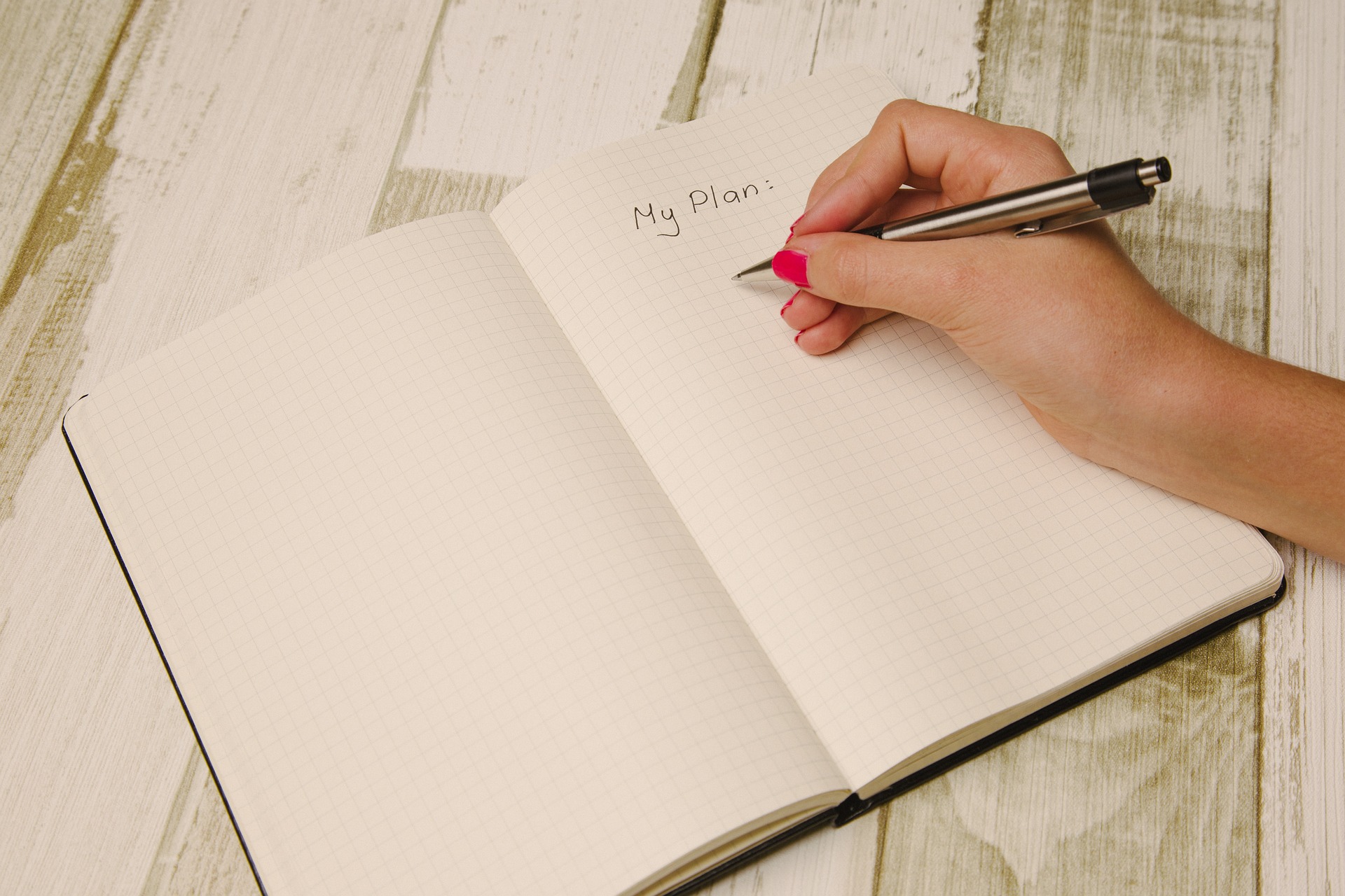 notebook and pen handwriting a plan